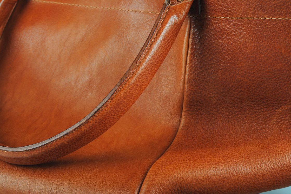 Gros plan sur un sac cognac, ses coutures et son grain