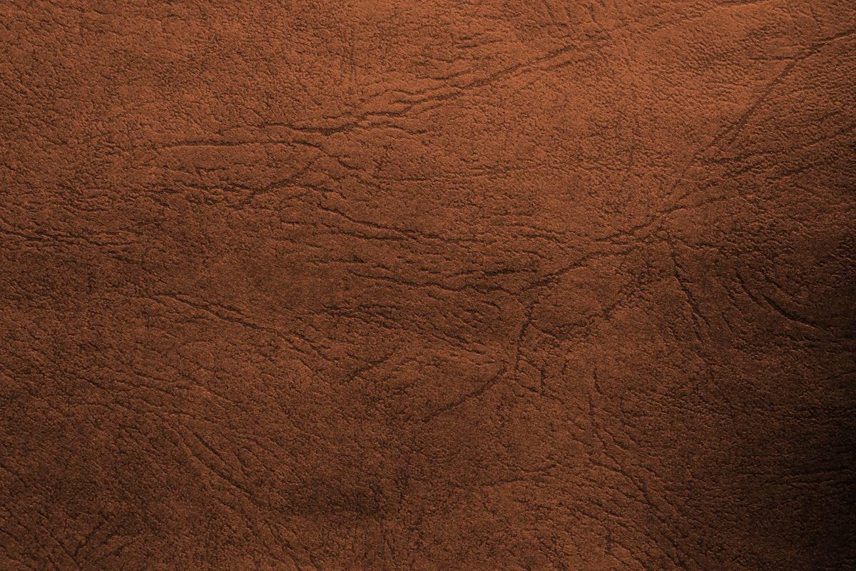 Gros plan sur une surface de cuir brun et ses variations de texture