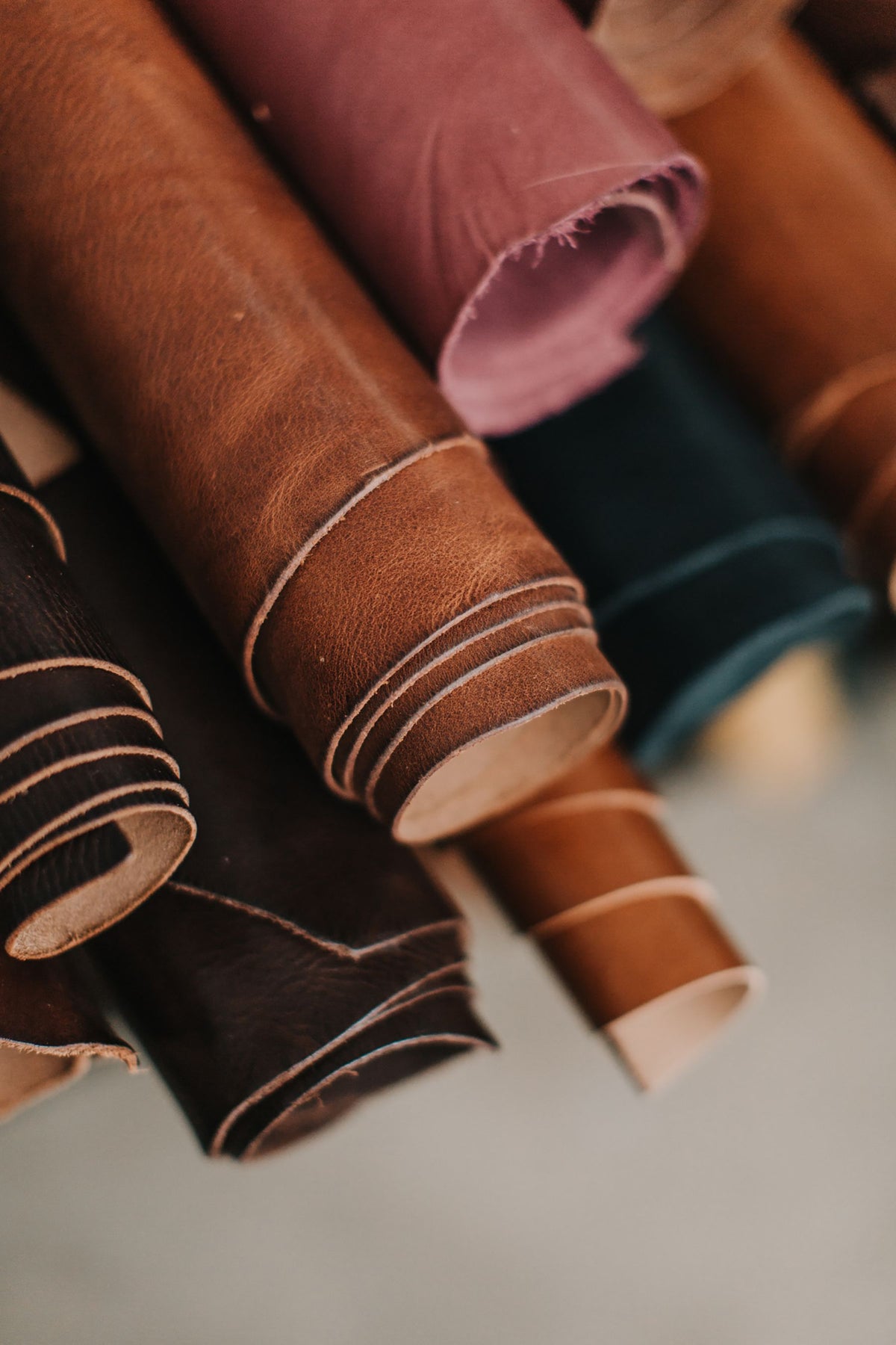 Rouleaux de cuir de plusieurs couleurs rangés dans un atelier.